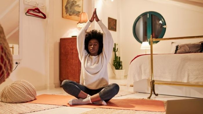 Student does yoga in bedroom