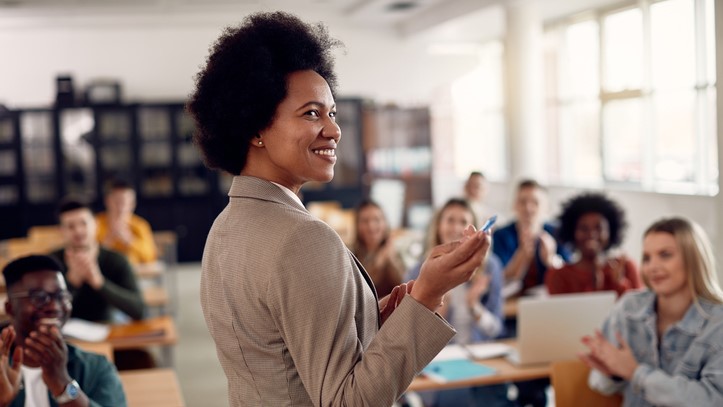 Lecturer points at board in front of class