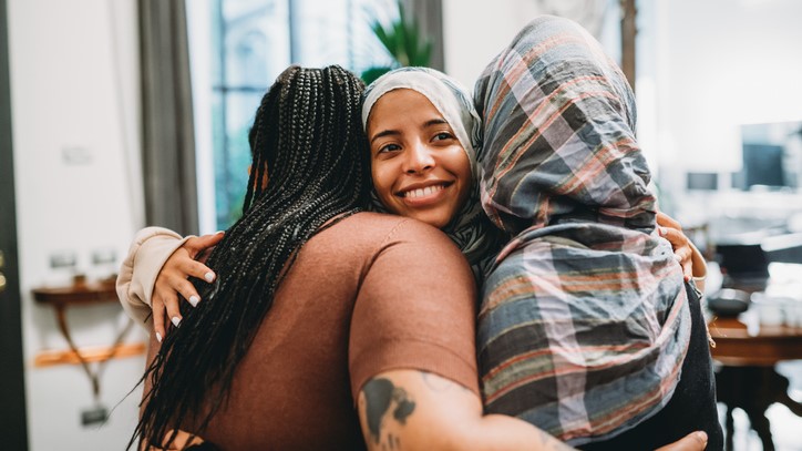 Three students hug